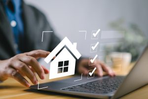 Man looking at virtual house in front of keyboard.